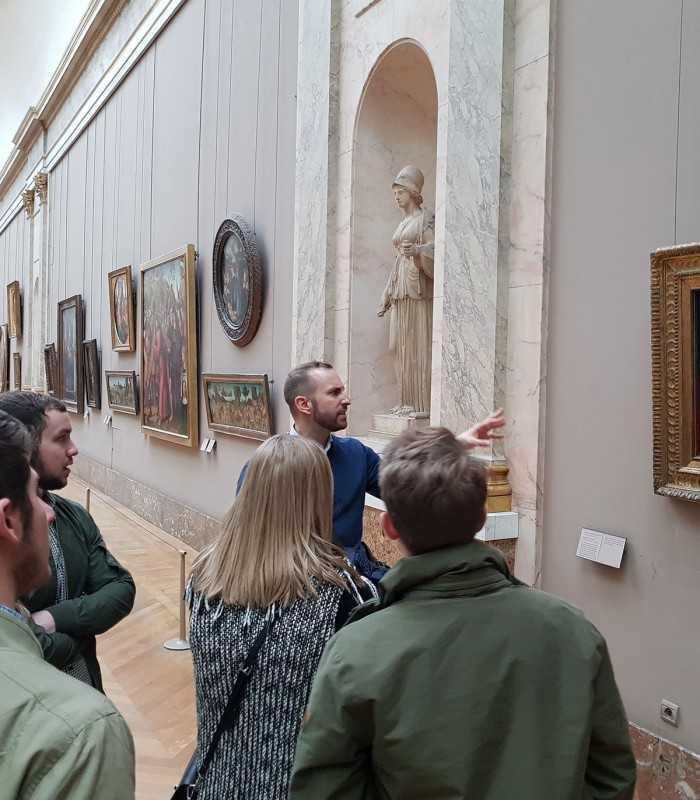 Private guided Louvre visit with an expert tour guide discussing famous paintings with guests