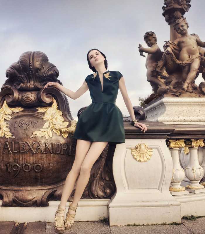 Visitor posing on Pont Alexandre III in Paris next to ornate statues during a private guided tour.
