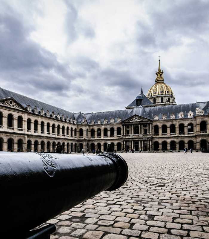 Inner courtyard of Les Invalides in Paris, France, featuring a historic cannon on display during a private tour