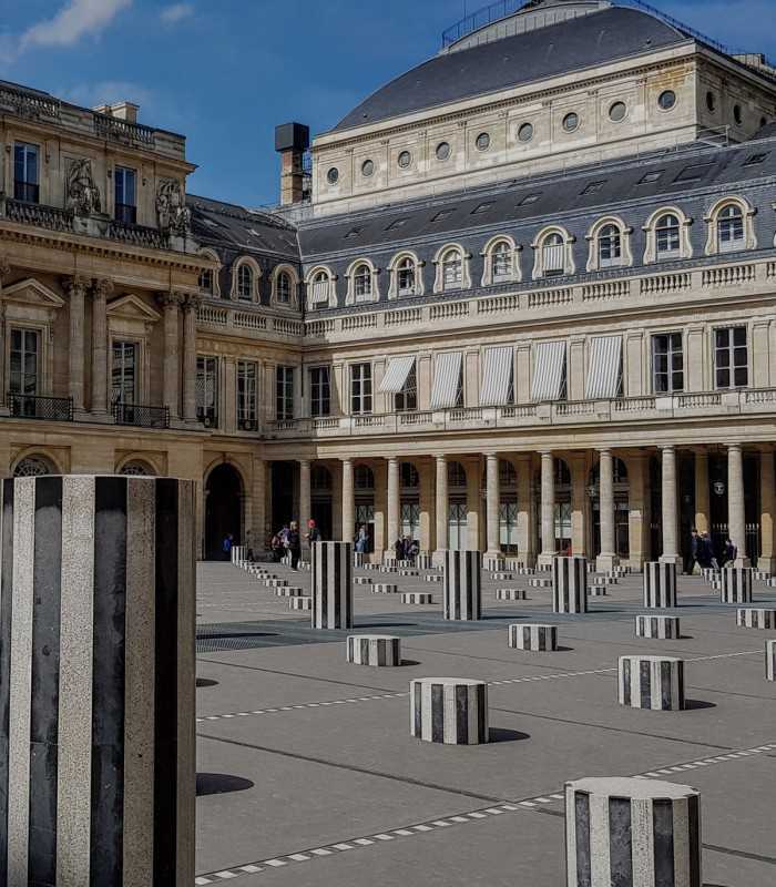 Exploring the Palais Royal courtyard with Buren’s contemporary striped columns on a guided Paris tour