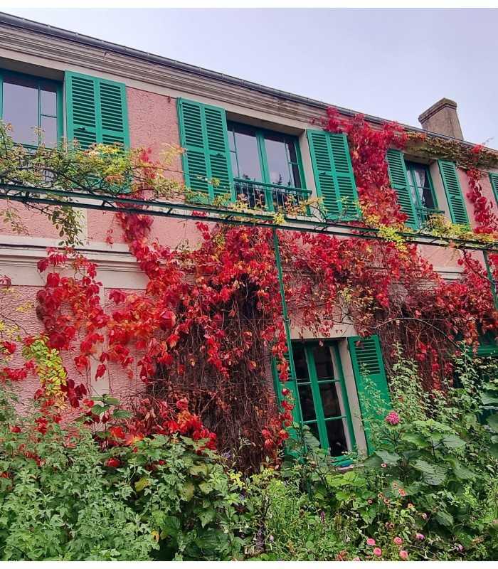 Monet’s house in Giverny covered with beautiful red ivy during the fall on a private tour.